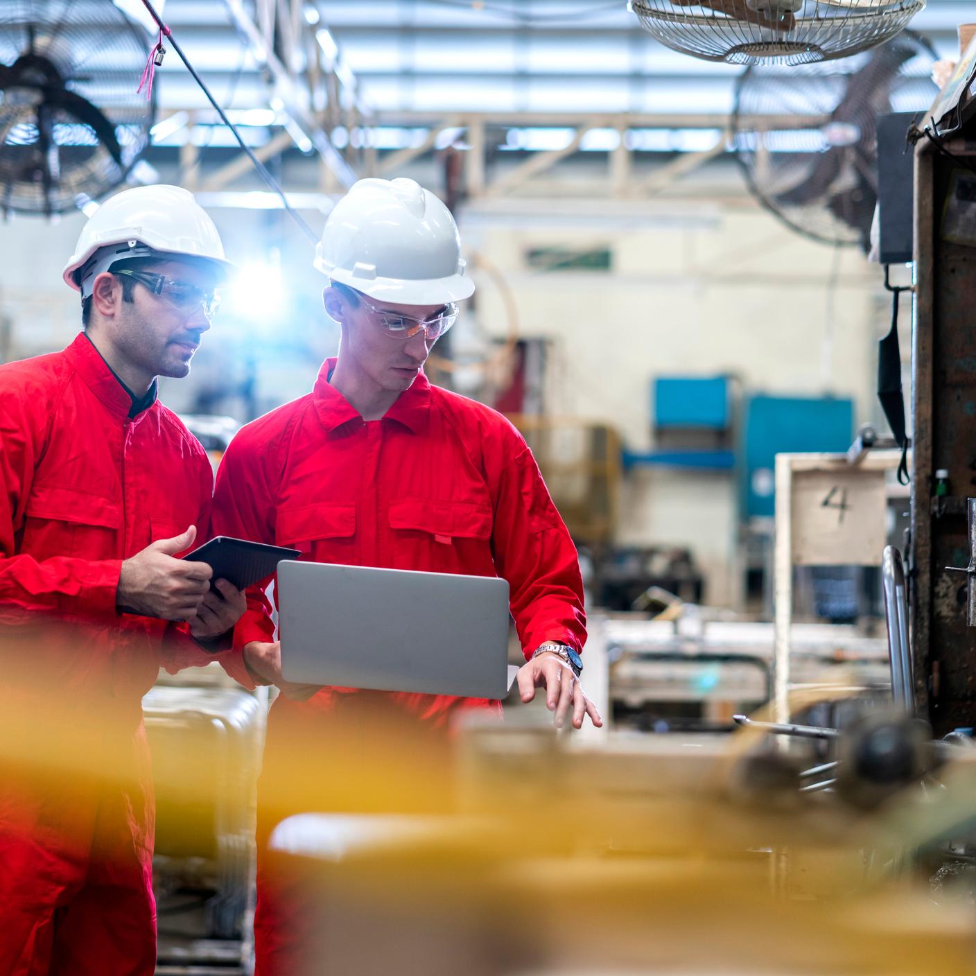 Confianza digital: trabajadores de la construcción con un portátil en una fábrica